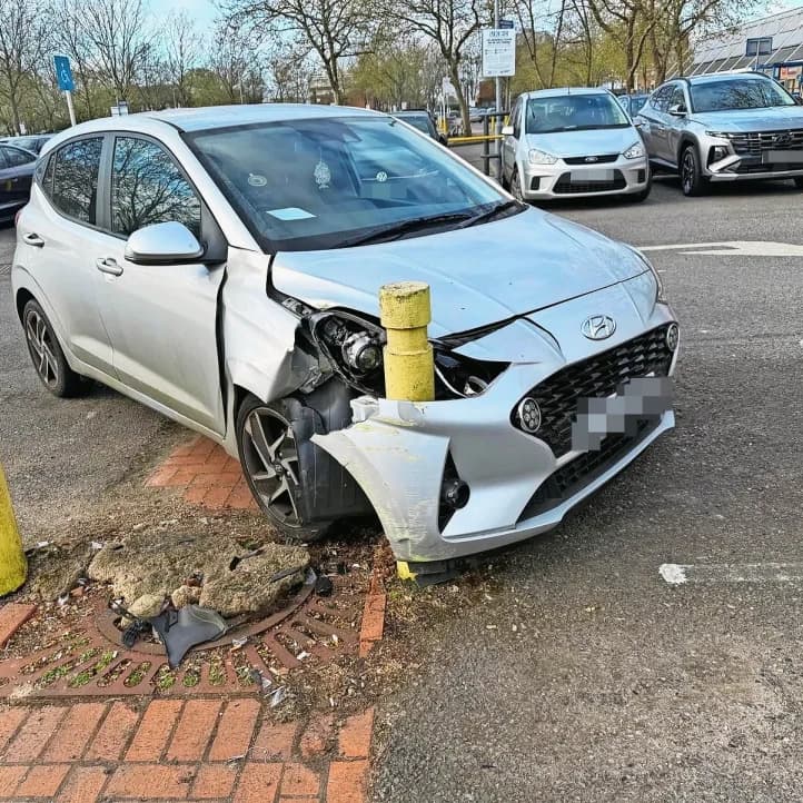 A vehicle reverses into a traditional bollard.